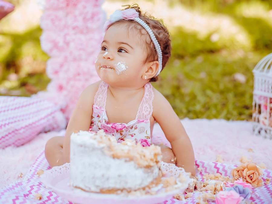 A baby at a full moon celebration with a cake