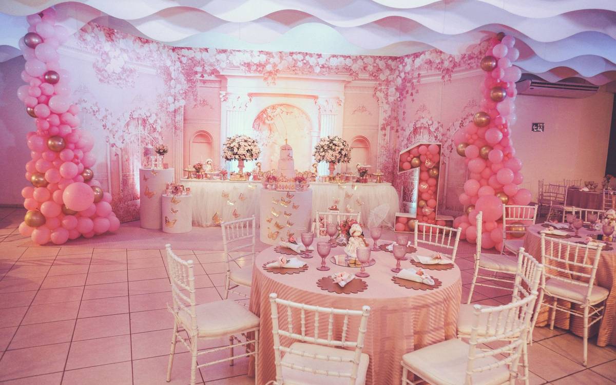 A decorated party room set up in pink and gold
