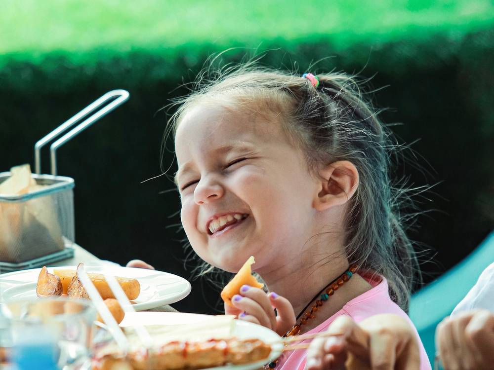 A child laughing over lunch at the cafe