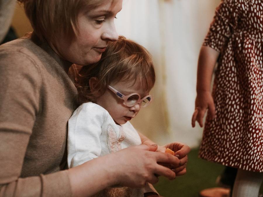 A carer playing with a toddler in the baby zone